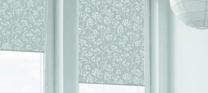 Elegant floral patterned roller blinds in soft blue hues.