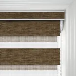 Brown roller blinds in a white window frame.