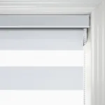 Close-up of white roller blind with pull cord.