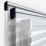 Close-up of modern window blinds with chain controls.