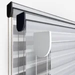 Close-up of blinds with pull chains on white background.