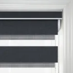 Modern black and white striped roller blinds in window.