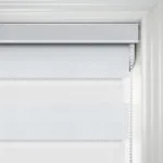 Close-up of white fabric roller blind on window