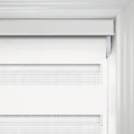 Close-up of white roller blind on window.