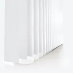 White vertical blinds in soft light, minimalist design.