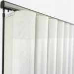 Close-up of white textured vertical blinds on rail.