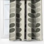 Patterned green and beige curtains in front of window.