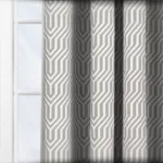 Geometric pattern curtains on window in sunlight.