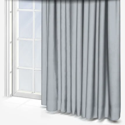 Grey curtains draped beside a large window.