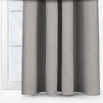 Grey curtains in front of a white window frame.