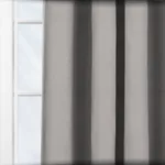 Grey striped curtains over a sunlit window.