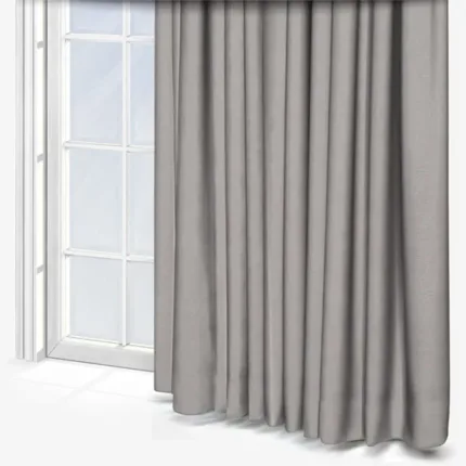 Grey curtains beside a glass window in a white room.