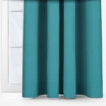 Teal curtains in a bright, white windowed room.