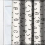 Curtains with black and white eye patterns near window.