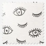 Embroidered eyes pattern on white fabric swatch.