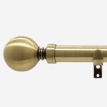 Antique brass curtain rod with finial on white background.