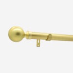 Brass curtain rod with finial on white background.