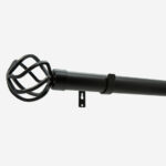 Black curtain rod with decorative cage finial on white.