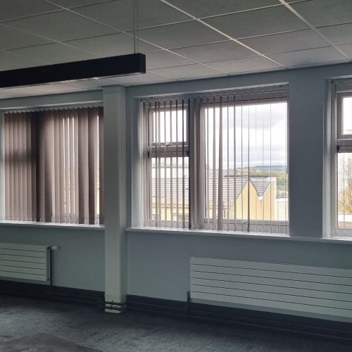 Interior view of room with windows overlooking urban landscape.