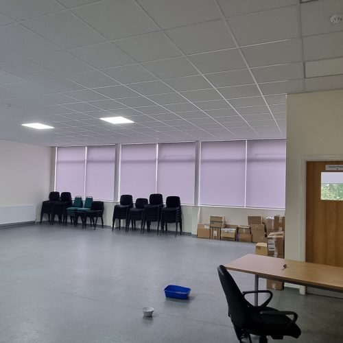 Empty meeting room with chairs, table, and ladder.