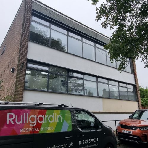 Modern building with bespoke blinds van parked outside.