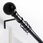 Black curtain rod with spherical finial mounted on wall